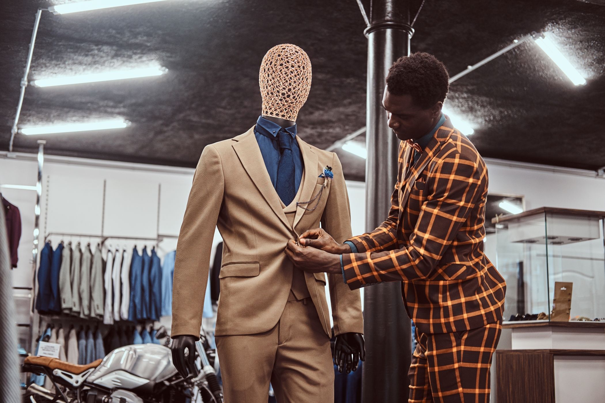 African-American man dressed in trendy elegant suit, working at classic menswear store in Miami.