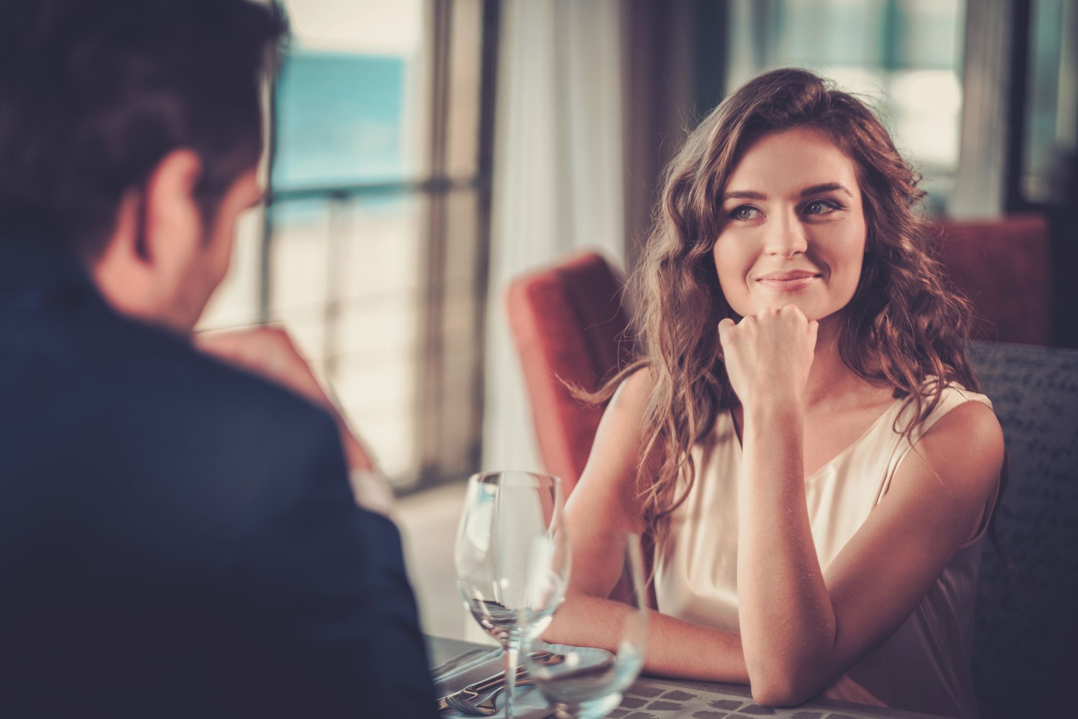 Young beautiful couple in a restaurant in Miami with the ocean in the background.