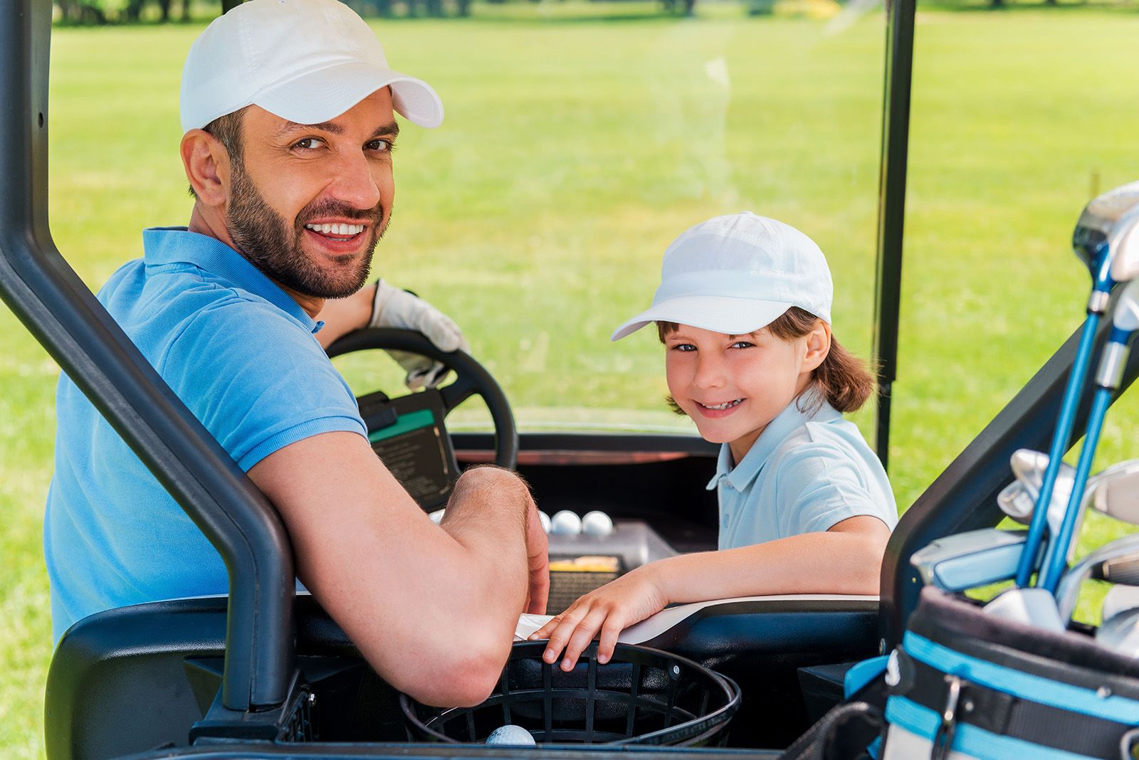 Father and son golfing for fathers day, sitting together in a golf cart in Miami.